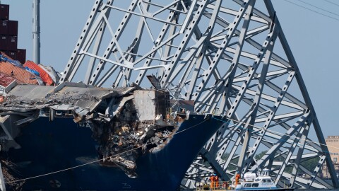 FILE - A boat moves past the bow of the container ship Dali prior to the detonation of explosive charges to bring down sections of the collapsed Francis Scott Key Bridge resting on the Dali, May 13, 2024, in Baltimore. (AP Photo/Mark Schiefelbein,File)