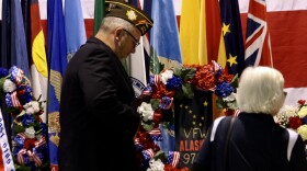 A veteran lays a wreath during the 2019 Veterans Day ceremony at Joint Base Elmendorf-Richardson on Nov. 11, 2019. (Photo by Joey Mendolia/Alaska Public Media)