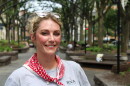 a blonde woman in a park smiles at the camera 
