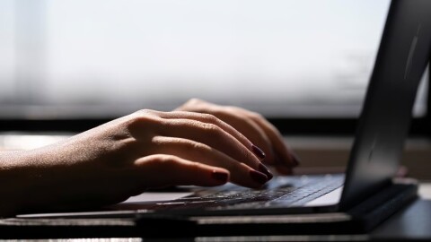 FILE - This May 18, 2021, photo shows a woman typing on a laptop on a train in New Jersey.