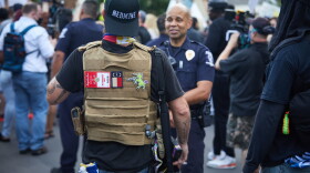 A member of the far-right militia, Boogaloo Bois, walks next to protesters demonstrating outside Charlotte Mecklenburg Police Department Metro Division 2 just outside of downtown Charlotte, North Carolina, on May 29, 2020. (Logan Cyrus/AFP/Getty Images)