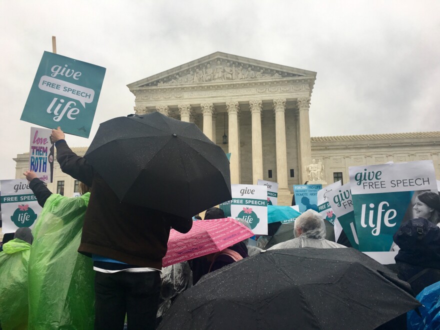 Anti-abortion activists protest in the rain in front of the Supreme Court. The court is hearing arguments Tuesday on the state of crisis pregnancy centers.