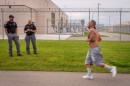 An inmate jogs past guards and security fencing during the Fit From Within half-marathon inside the Utah State Correctional Facility in Salt Lake City, June 18, 2025.