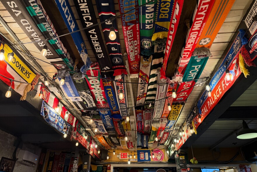 Colorful scarves, representing teams from New York City FC to Japan's Samurai Blue, line the ceiling at 2nd Bridge Soccer Pub in Manchester, Connecticut, where watch parties will be held for each match of the 2026 FIFA World Cup.