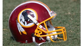 A Washington Redskins football helmet lies on the field during NFL football practice.