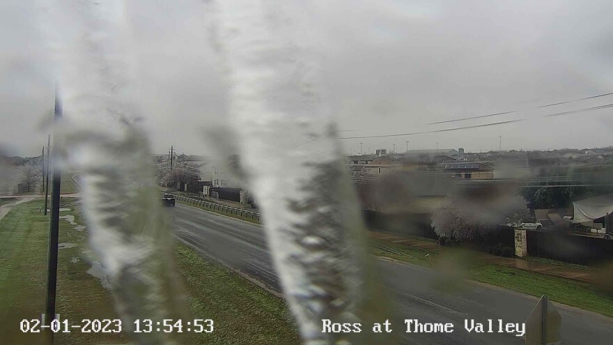 A city of Austin traffic camera partially obscured by ice overlooking Ross Road.