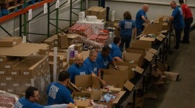Volunteers with Food Lion pack goods into boxes at Golden Harvest Food Bank's volunteer center in Aiken. The group packed 460 boxes.