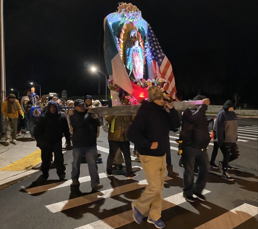 People take turns carrying the statue of Our Lady of Guadalupe as the procession begins in Lexington.