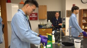 Left, senior Victor Wong puts on gloves at at a lab at Western Reserve Academy in Hudson devoted to cancer immunology research.