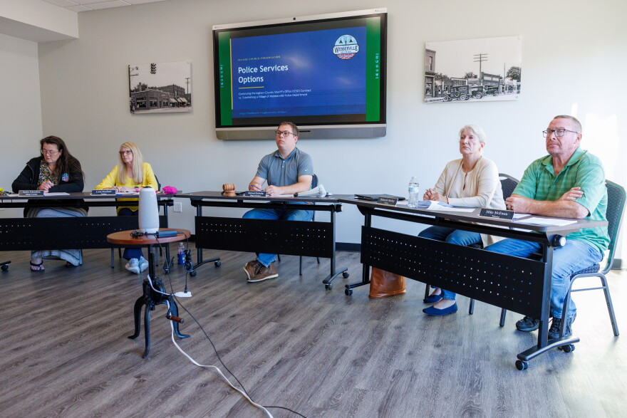 The Webberville Village Council at its meeting, with members sitting in a line at tables.