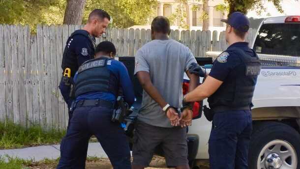 Sarasota Police Officers arrest a man on June 16 on a warrant for failure to appear. The arrest happened outside the Resurrection House, a homeless day shelter in downtown Sarasota, where officers recognized the man when he entered to seek services. Officer Nathan Lynn (left) said the officers had no choice but to arrest the man because of the warrant, but he was confident the charge would be dismissed, as the man had only failed to appear in court because he was in a drug recovery program in another county.