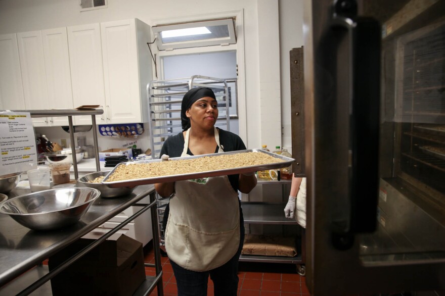 Colida Johnson, a graduate of the program who is now a program assistant, puts granola in the oven.