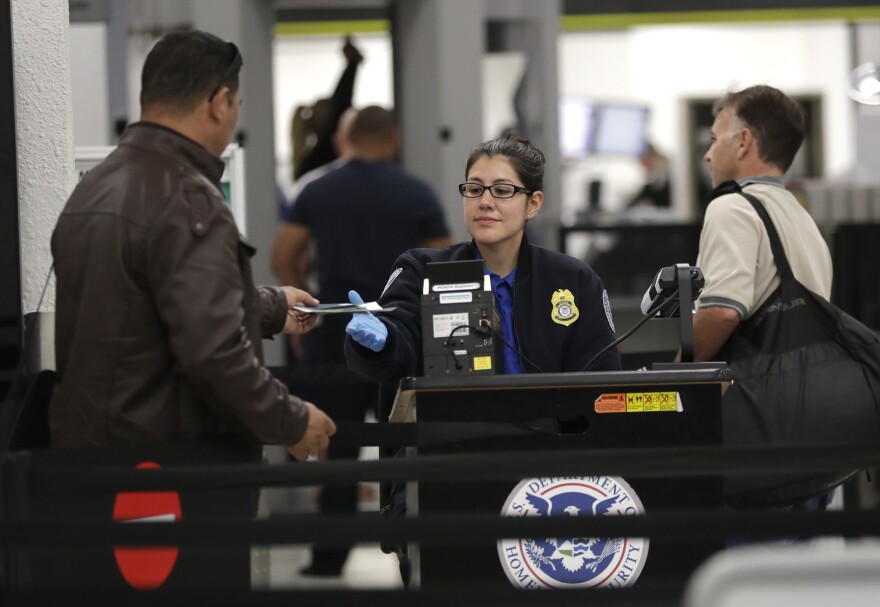 A Transportation Security Administration officer works at a checkpoint at Miami International Airport