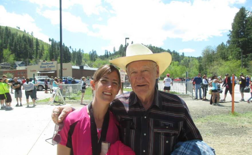 Angie Sewalson taking a picture with her grandfather, John Baumann, after finishing Finished a half marathon in Deadwood, SD.