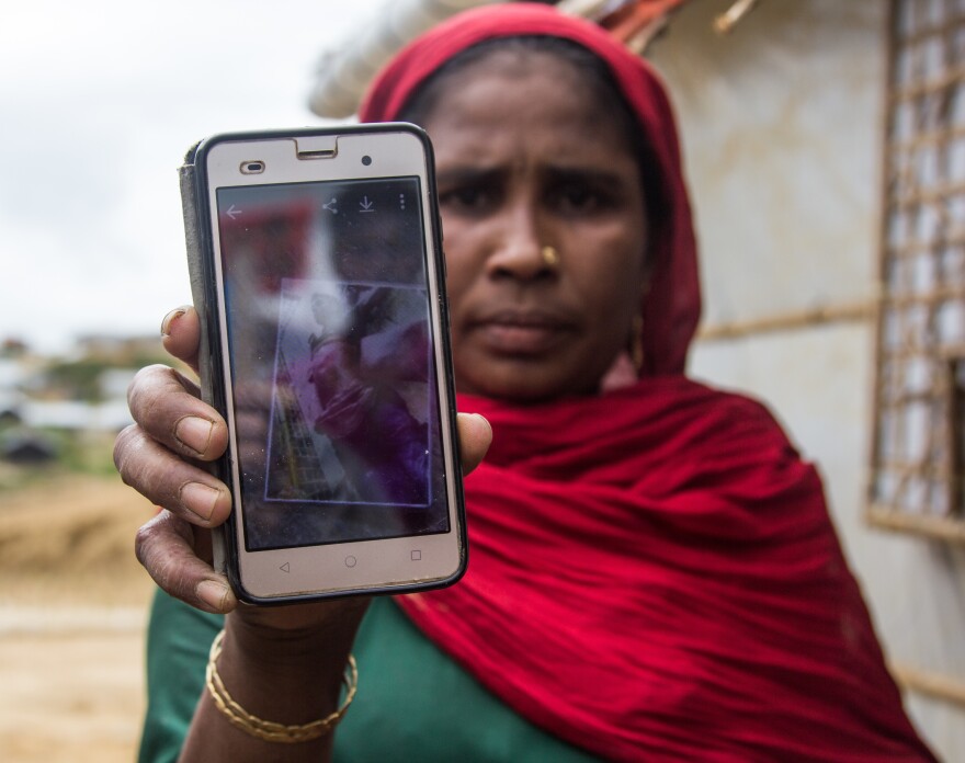 Rohingya refugee Roshedha Begum, 40, holds up a photo of her son's dead body. He was killed, she says, by Myanmar soldiers during the violence last year that drove more than 700,000 Rohingya into Bangladesh.