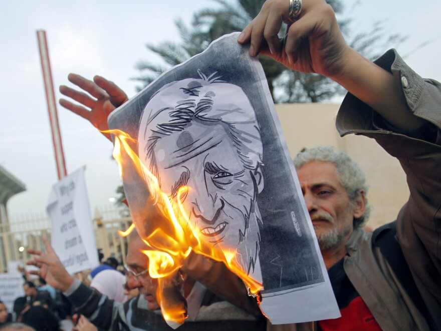 Egyptian activists burn a poster depicting Secretary of State John Kerry outside the Egyptian Foreign Ministry in Cairo on Saturday. Some accuse Kerry of supporting the Islamist government.