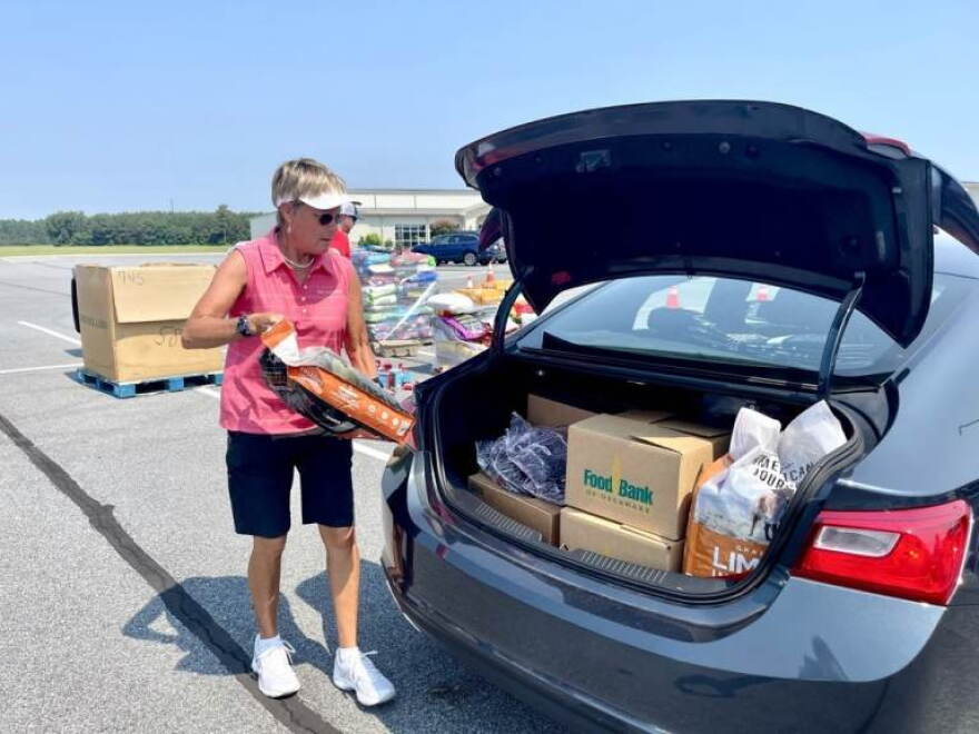 Volunteer Judy Stout helps load a trunk with food at the Food Bank of Delaware's monthly drive-thru distribution at the Crossroad Community Church in Georgetown.