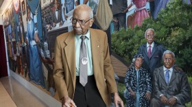 David Anderson, a professor and noted Frederick Douglass scholar, at the December 2021 unveiling of the Douglass mural in the Frederick Douglass Greater Rochester International Airport. Anderson is included in the mural. Michelle Daniels, who commissioned the painting, said Anderson was invaluable in its development.