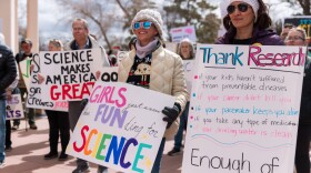 Protesters hold sign at the first Stand Up for Science rally held at the Santa Fe Roundhouse in March 2025.