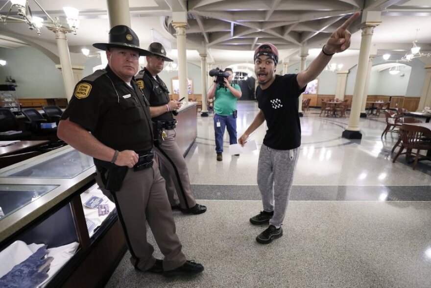 In this June 19, file photo Matthew Bruce, of Des Moines, right, talks with Iowa State Patrol officers during a Black Lives Matter demonstration outside the governor’s office at the Statehouse.