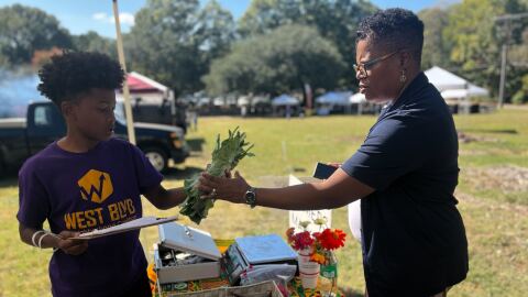 Vinnie Morris grabs a handful of collard greens sold at the festival.