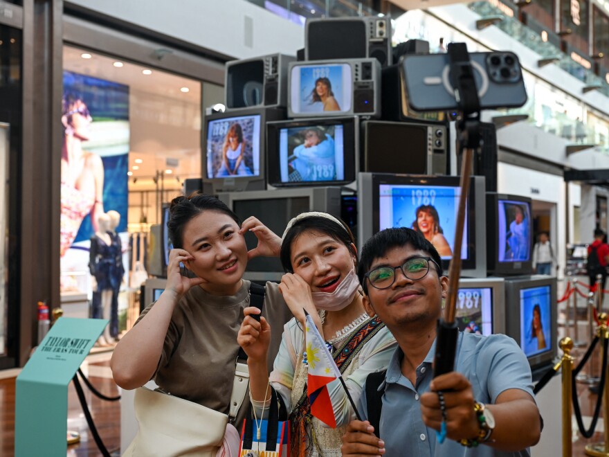 Fans of singer Taylor Swift take pictures next to an installation in the "Eras Tour Trail" that depicts different eras of the pop star's career, at the Marina Bay Sands complex in Singapore, on Feb. 28. More than 300,000 Swifties from Singapore and neighboring countries will attend the U.S. superstar's six sold-out Eras Tour shows at the National Stadium from March 2-9.