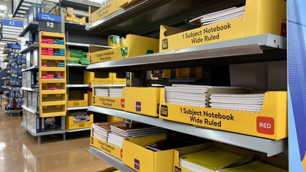 An end cap of an aisle at Walmart holds yellow boxes of notebooks. 