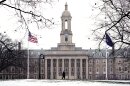 A student makes their way past Old Main on the Penn State campus in State College, Pa., Tuesday, March 17, 2026.