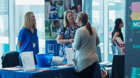 Representatives for the Goodwill Nurse-Family Partnership speak with a summit attendee on Tuesday, during the Labor of Love Summit at the JW Marriott Indianapolis.