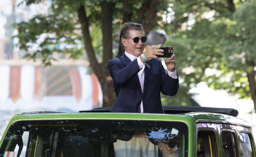 Steve Garvey, who played Major League Baseball for the Los Angeles Dodgers and San Diego Padres from 1969 to 1987, takes a photo of the crowds along the Little League World Series parade route. He served as the parade's grand marshal.