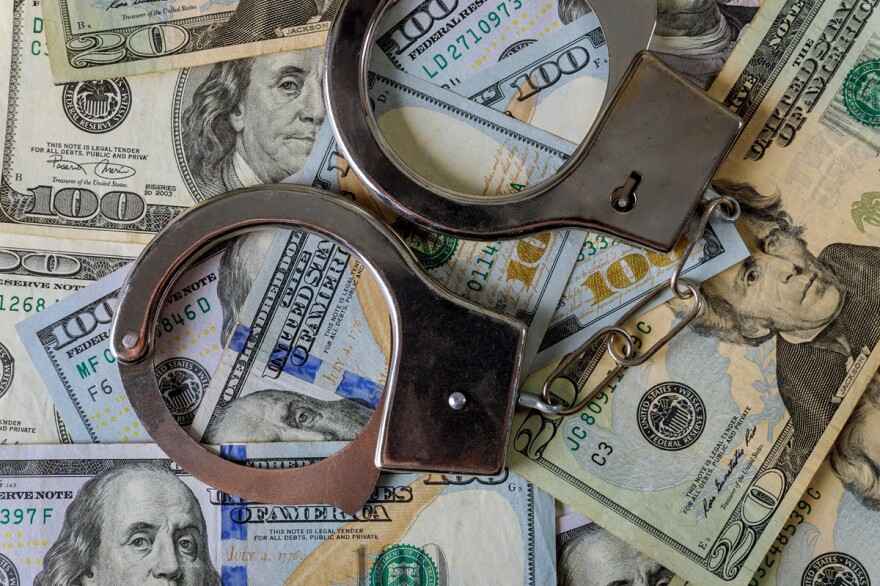 Handcuffs lay across US dollars