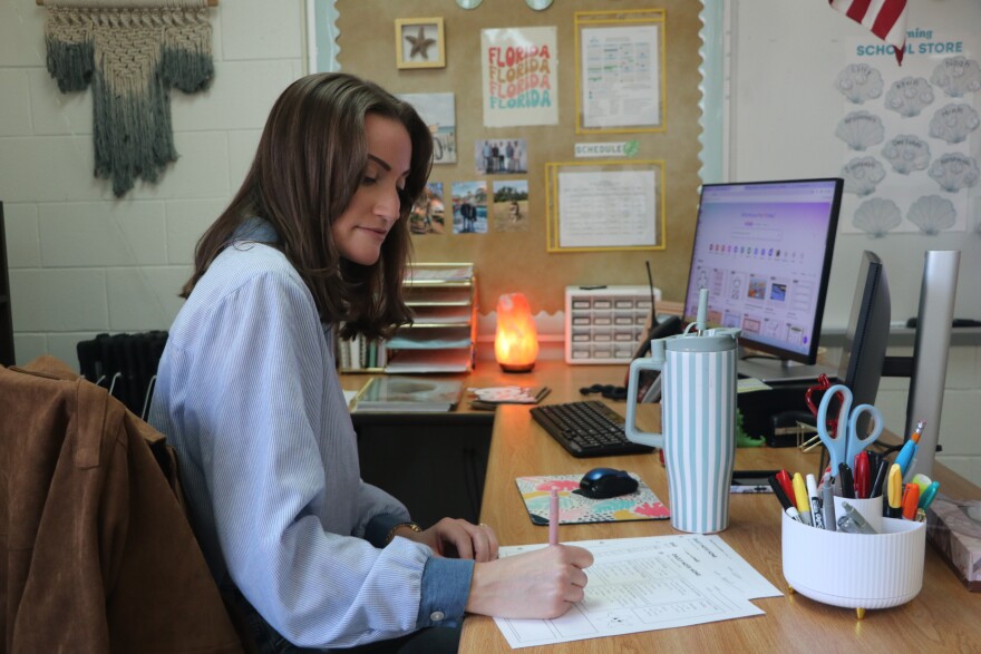 Stephens writes daily notes to send home to parents, updating them on their child’s behavior and progress on Tuesday, Feb. 10, 2026. “I feel like the parents appreciate that because sometimes our kids have tough mornings and tough days,” Stephens said. “And they also like to celebrate wins with the parents too, sending them pictures, keeping them in the loop of fun activities we have coming up and resources that we send home that the kids can use too.” (Amanda Roman/WUFT News)