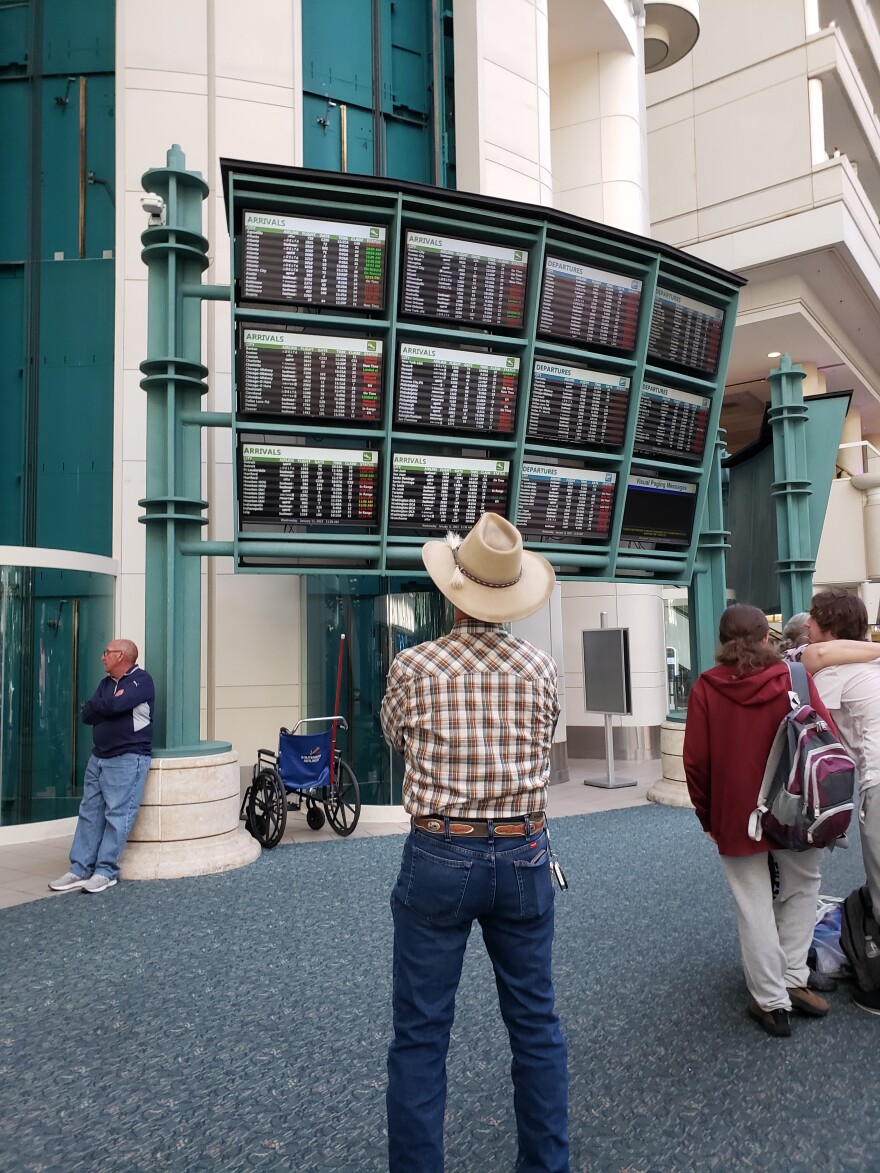 Orlando International Airport traveler studies the arrival/departure board