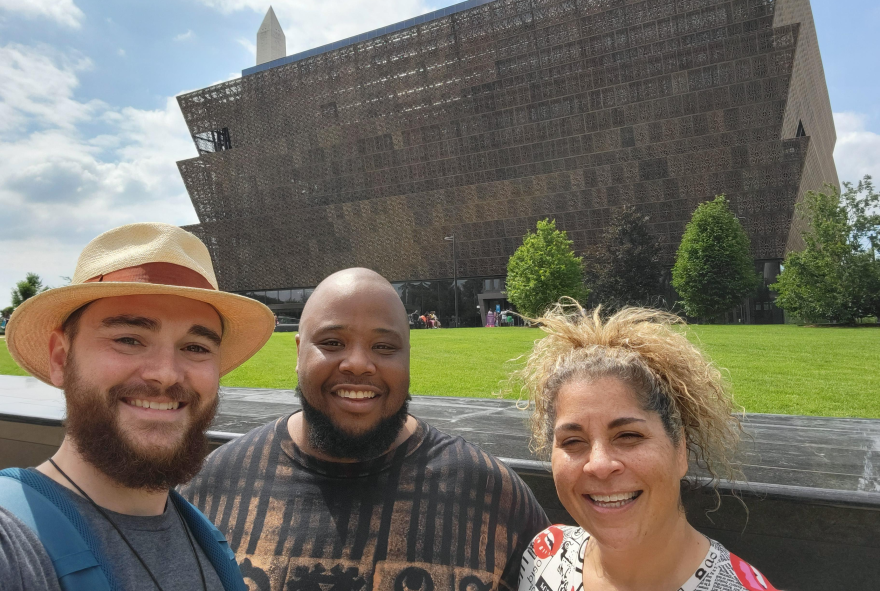 New Haven teachers Kurt Zimmerman, Garrett Griffin Jr. and Rayna Walters take a selfie in front of the Smithsonian National Museum of African American History & Culture. 