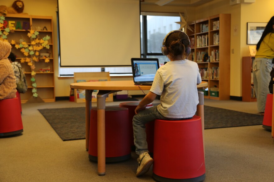 A student at Tenderloin Community Elementary School practicing reading with Amira.