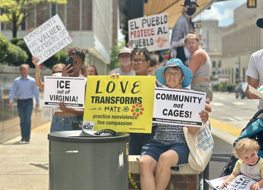 Protesters hold signs outside Richmond City Hall in August during a rally against Immigration and Customs Enforcement (ICE) detentions, calling for the city to bar local cooperation with federal immigration authorities.