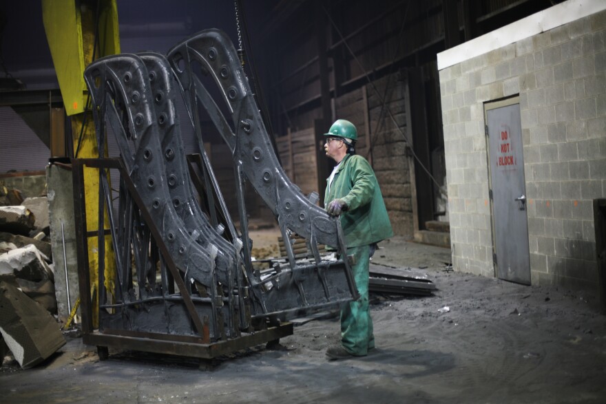 Dan Hensley lines up piano plates just removed from the molds, now off for finishing and painting.