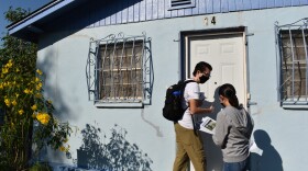 Juan Ruiz of the No Border Wall Coalition and a volunteer leave a flyer at a house in the Laredo neighborhood of Azteca. It's one of the riverfront neighborhoods that could they fear will be hurt by border wall construction.