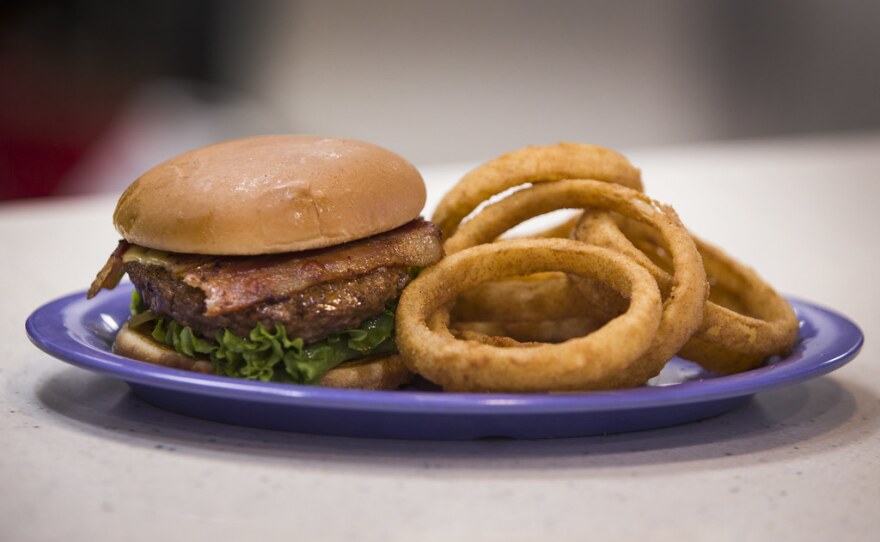A hamburger and onion rings.