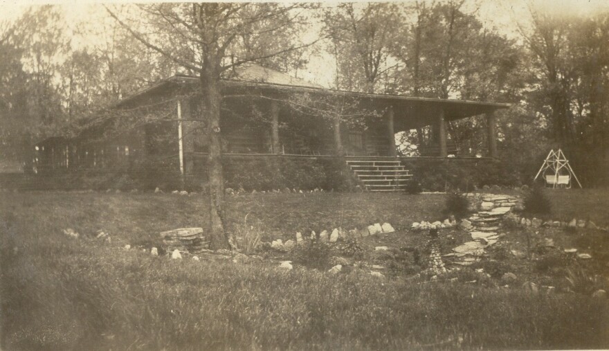 A black and white photo of a log cabin