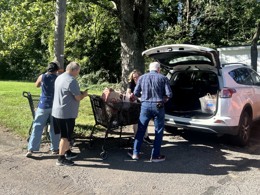 Volunteers unload groceries outside the Eastern Area Community Ministries in Louisville at the start of the city-wide food drive.