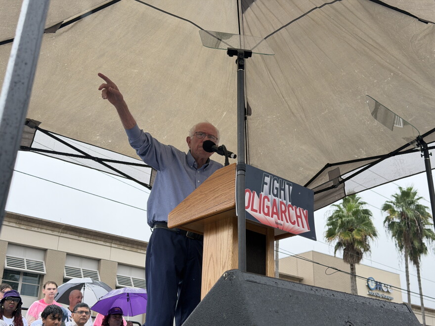 Man gesturing under a tent