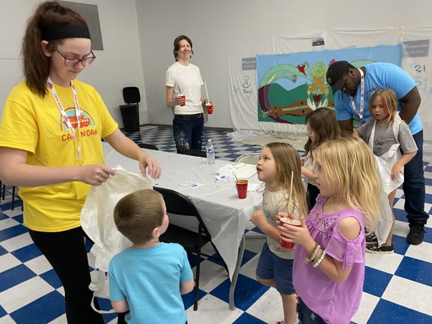 Children at Camp Noah in Floyd County prepare to paint a mural with themes of resiliency and sense of place.