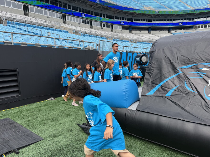 Football player surrounded by kids in stadium 