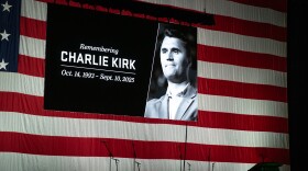 Inside UVU’s UCCU Center, a large American flag covered the back wall behind the stage and a screen showed a picture of Charlie Kirk, Sept. 19, 2025.