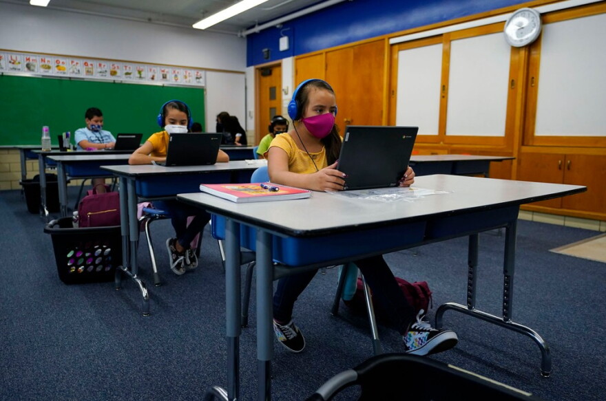 Reyna Najera works on a laptop in a classroom in Newlon Elementary School on Tuesday, Aug. 25, 2020. The school was one of 55 Discovery Link sites set up by Denver Public Schools where students could participate in remote learning from a school in Denver.