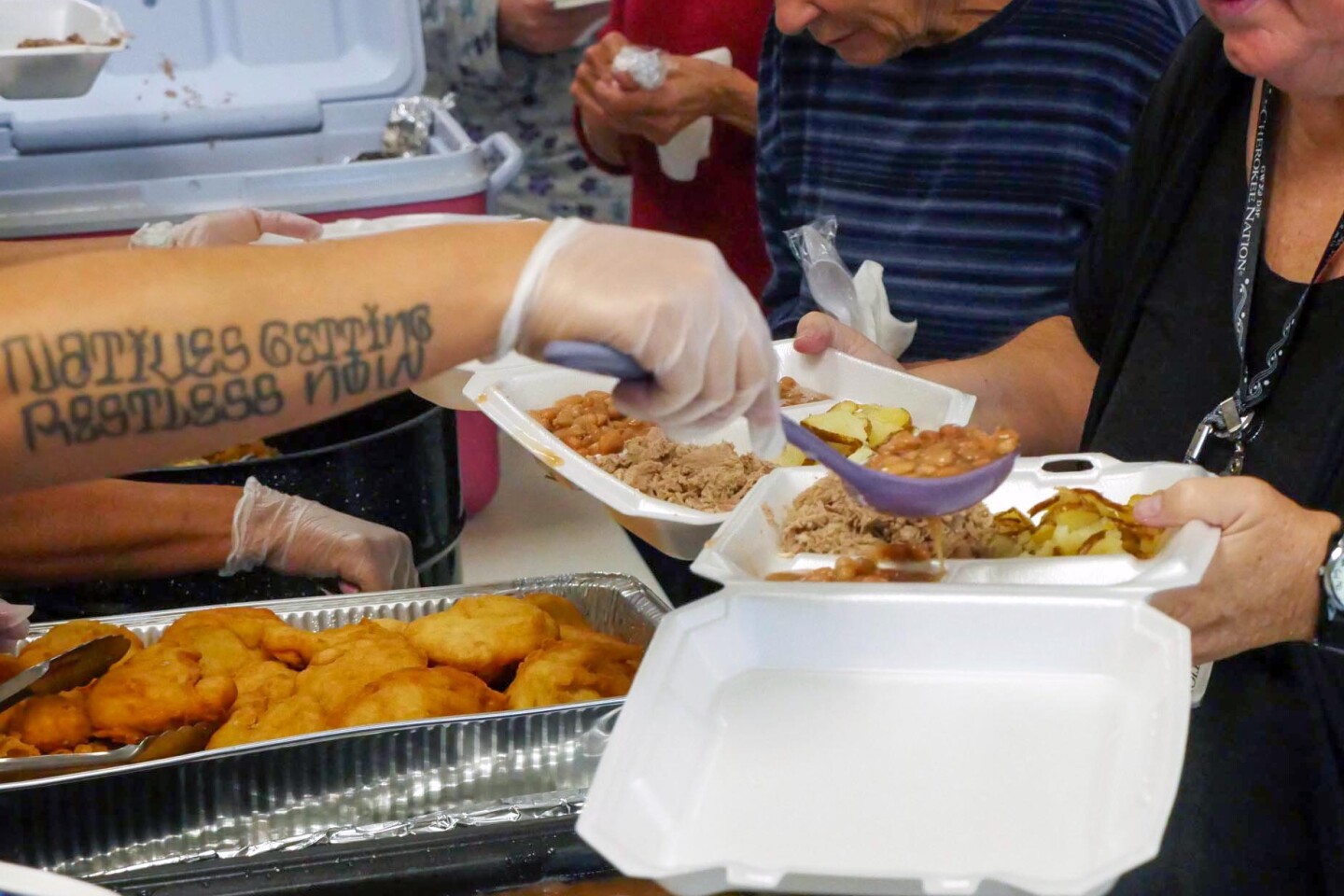 Tricia Fields Alexander serves grape dumplings, fry bread and beans at a hog fry in Catoos. Her traditional Native recipes have been passed down through generations.