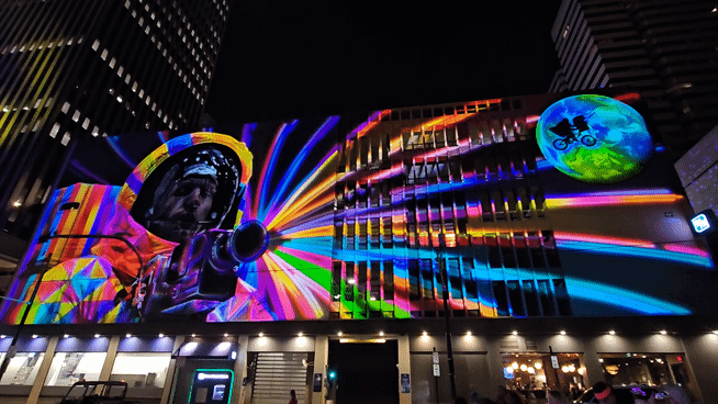 A gif of bright colors projected onto a mural of an astronaut.