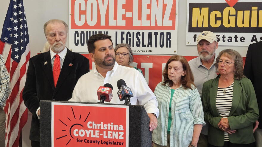 Erie County Republican Committee Chairman Michael Kracker, behind lectern, and Amherst Republican Committee Chairman Bob Davis, far-left, answer why they are calling for County Legislator Jeanne Vinal's resignation.