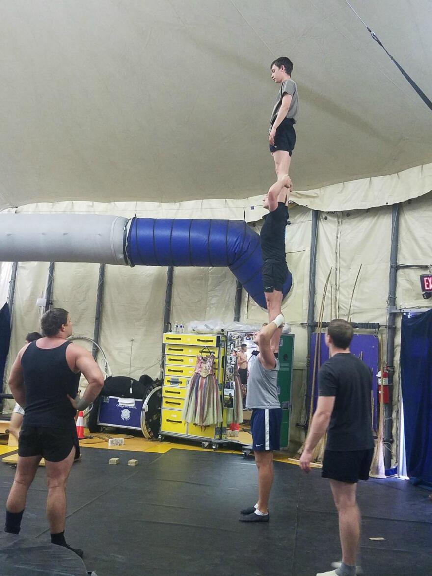 Performers practice for the show by standing on each other's shoulders and balancing.